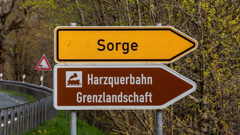 Straßenschild Richtung Sorge und Harzquerbahn Grenzlandschaft: Der Ortsname rührt daher, dass die Leute Sorge hatten, ihr Überleben zu sichern. 